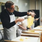 person holding freshly made pasta on a knife on EF Go Ahead's tour Food & Wine: Piedmont & Tuscany with America's Test Kitchen