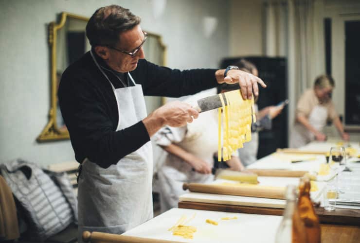 person holding freshly made pasta on a knife on EF Go Ahead's tour Food & Wine: Piedmont & Tuscany with America's Test Kitchen