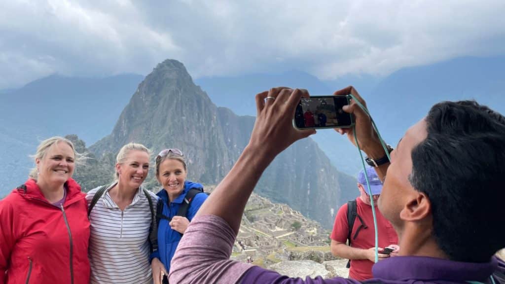 Adventures by Disney adventure guide taking picture of guests visiting Machu Picchu