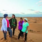 tour guests gathered on a sand dune on an Overseas Adventure Travel (O.A.T.) tour