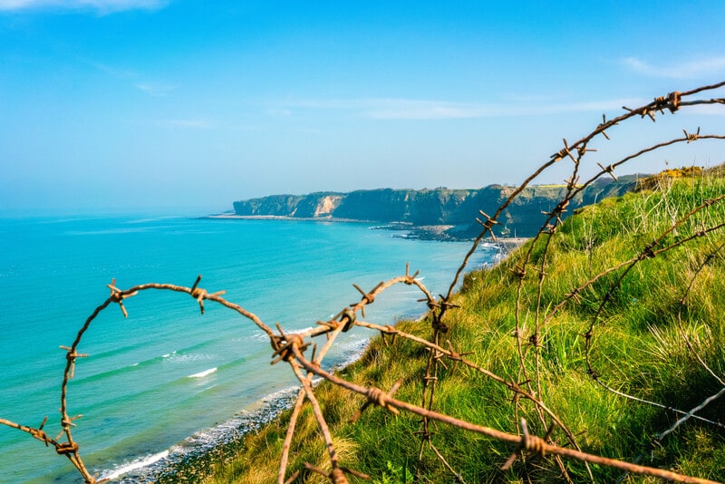view of D-Day beach through barbed wire