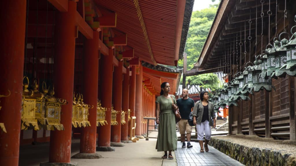 Tour guests walking through Kasuga Taisha Shrine on the island of Nara in Japan