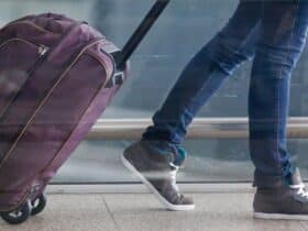 Woman walking through airport with luggage (Photo: Shutterstock)