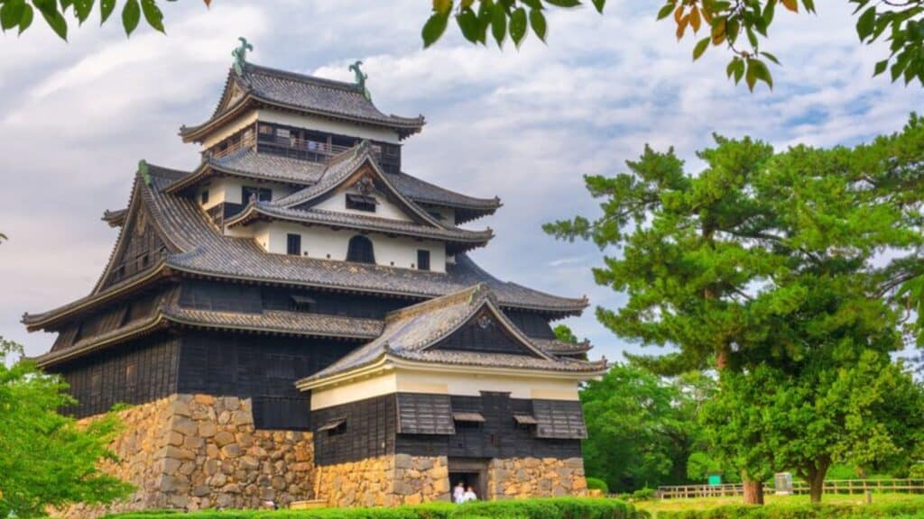 Matsue Castle in Japan with tree leaves framing the picture, as seen on a Smithsonian Journeys tour