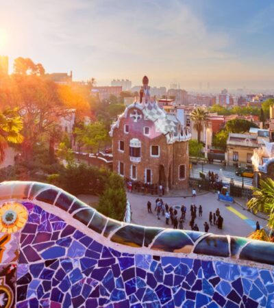 View of tour group on Spain tour early in the morning at Parc Guell in Barcelona with colorful mosaic wall in foreground