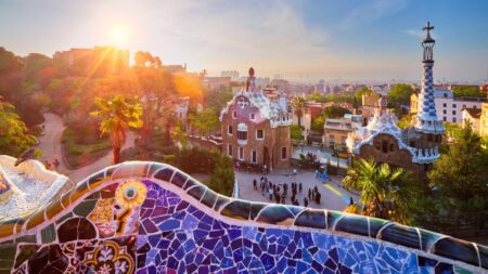 View of tour group on Spain tour early in the morning at Parc Guell in Barcelona with colorful mosaic wall in foreground