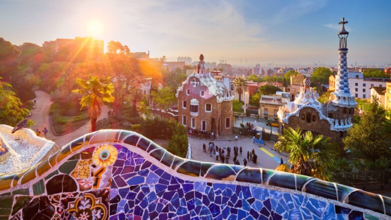 View of tour group on Spain tour early in the morning at Parc Guell in Barcelona with colorful mosaic wall in foreground