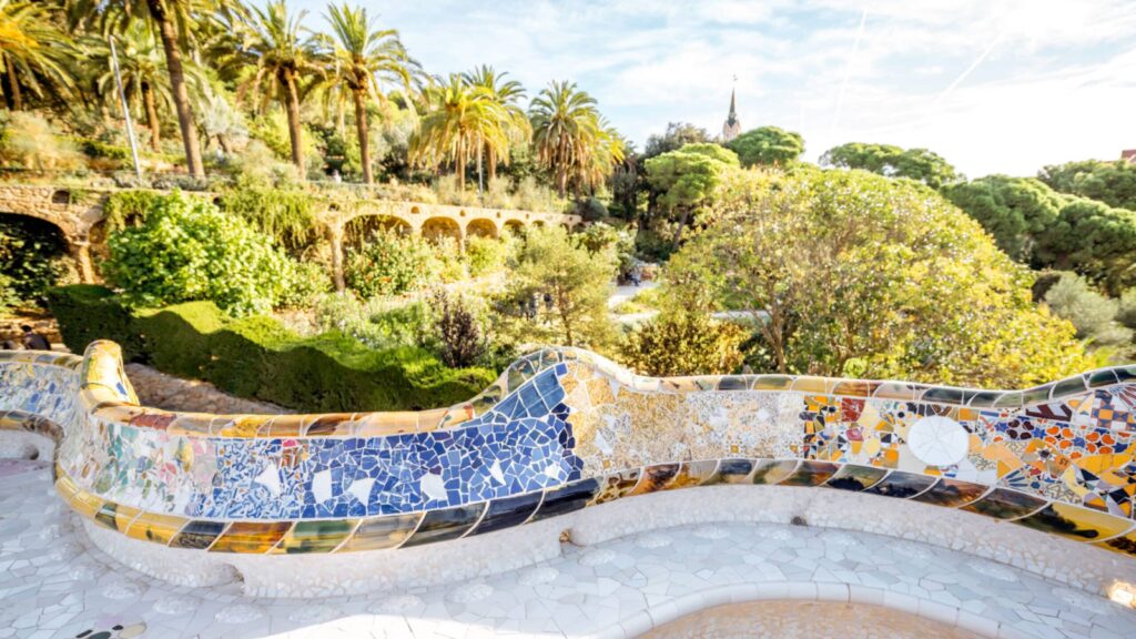 seating at Barcelona's Parc Guell, with trees and archways in the background