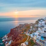 Sunset view over Oia with water in background on Santorini in Greece