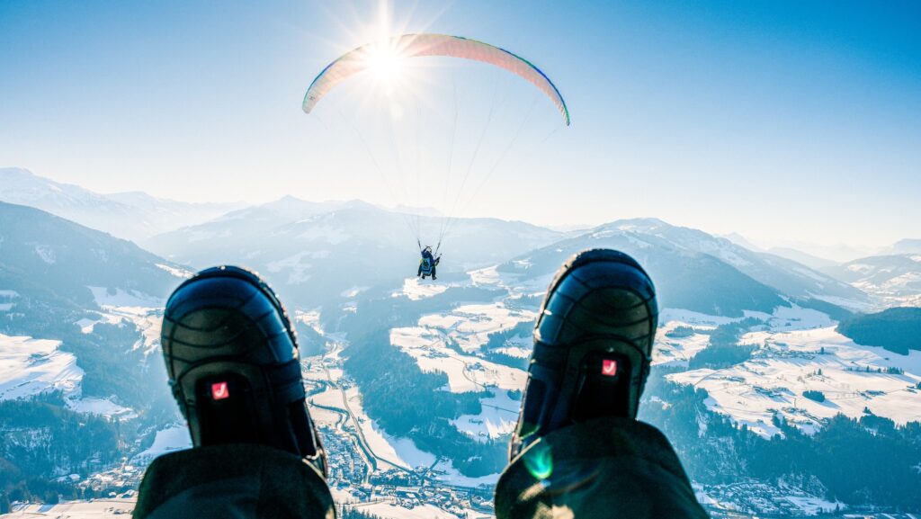 view of paraglider over Austrian Alps in Hopfgarten on Contiki tour