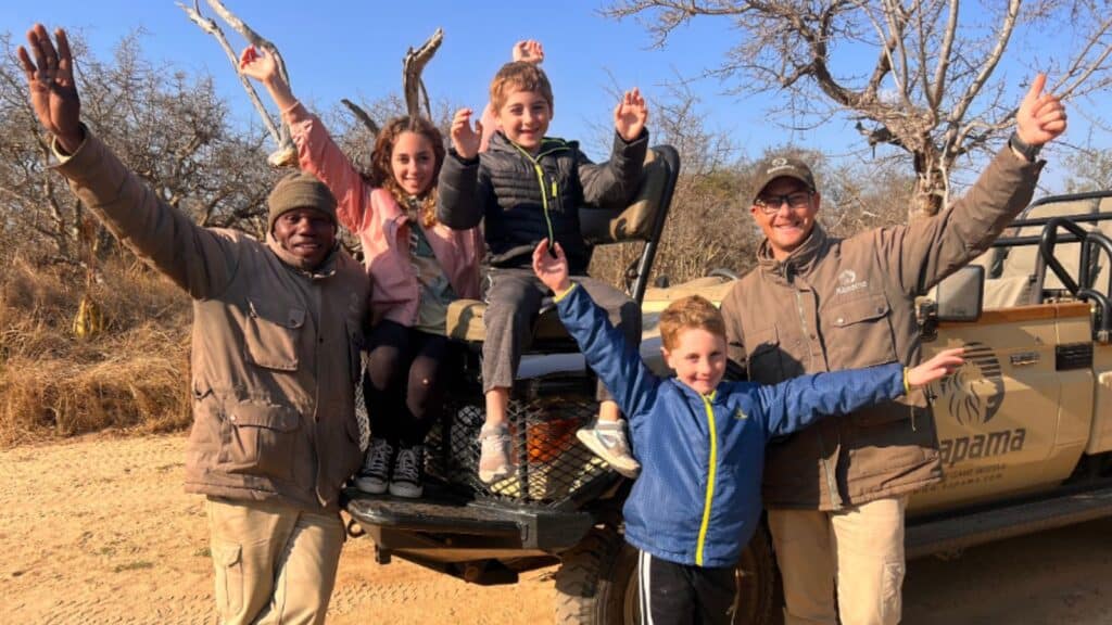 children, tracker, and guide on an Adventures by Disney South Africa tour game drive