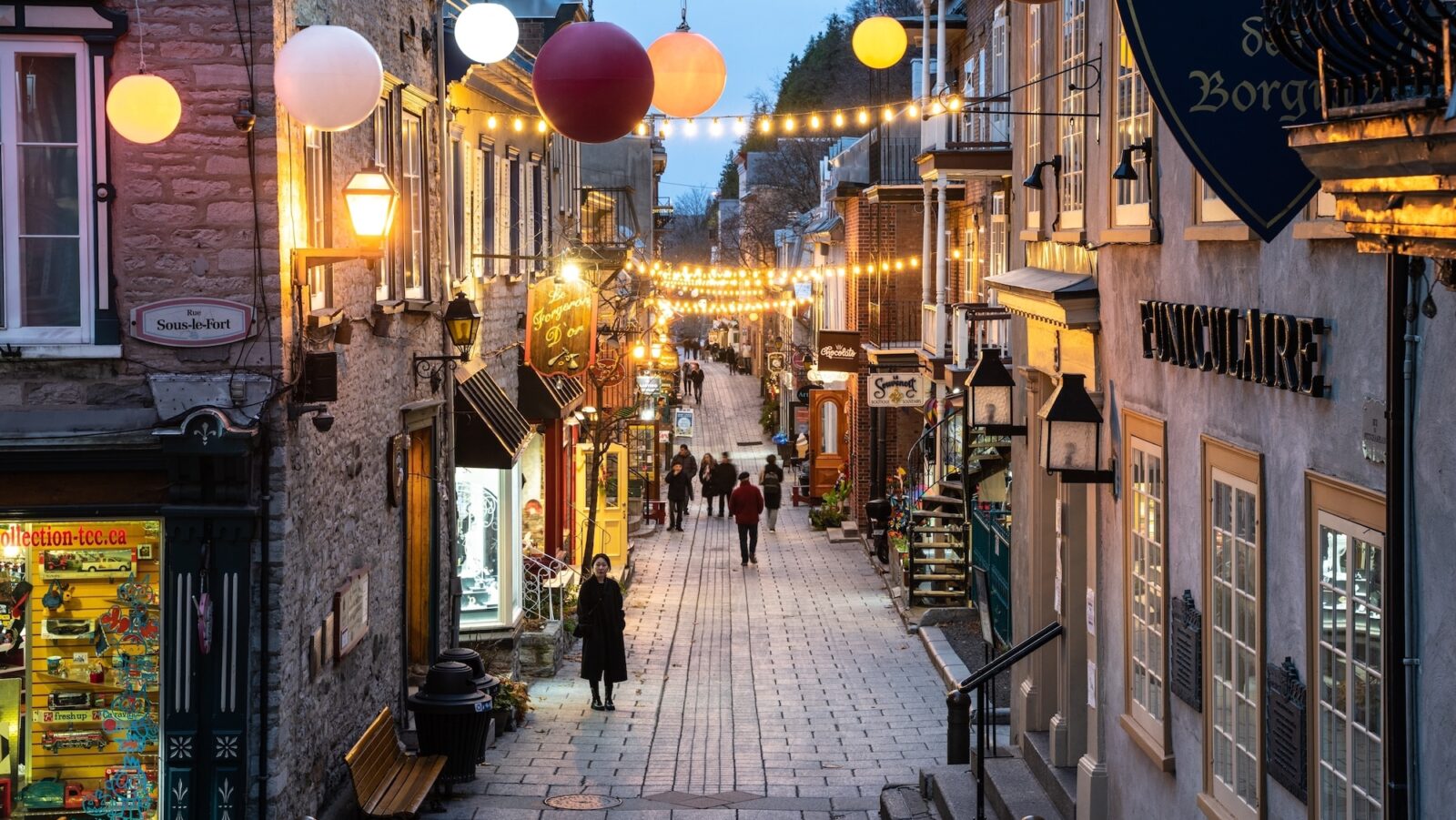 Historic lower Quebec City in Canada in the evening with festive lights and people strolling