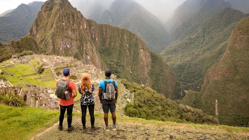 Three hikers looking out at Machu Picchu