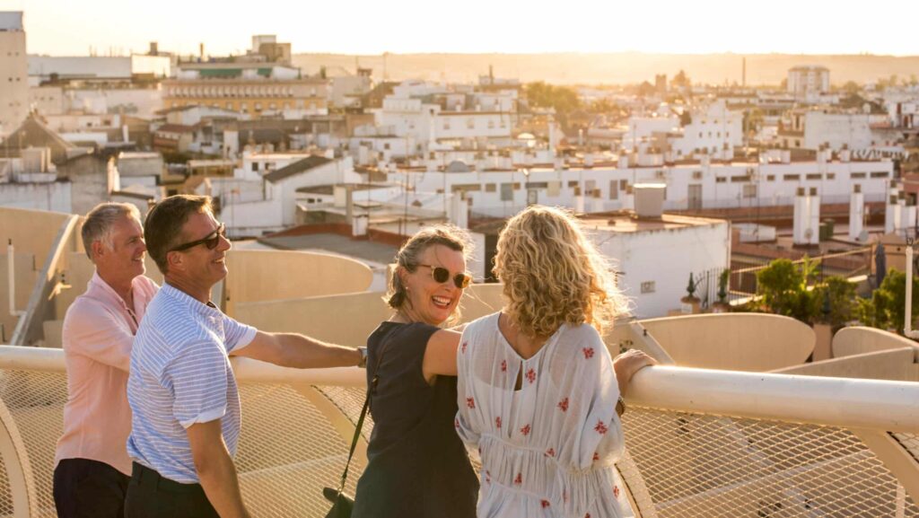 Two couples on a rooftop looking at a view of Seville, Spain