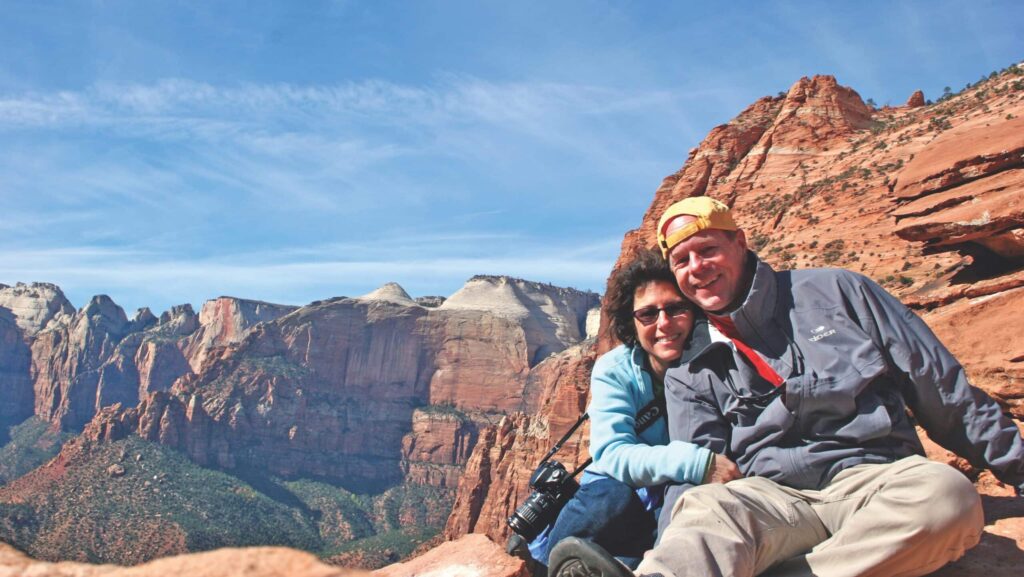 couple on a Tauck tour posing in front of red rocks