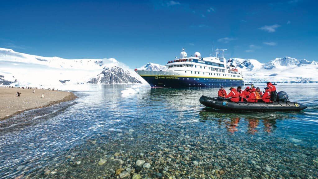 Guests zodiac land on Niko Harbor on a beautiful clear day from the ship National Geographic Orion, Antarctica