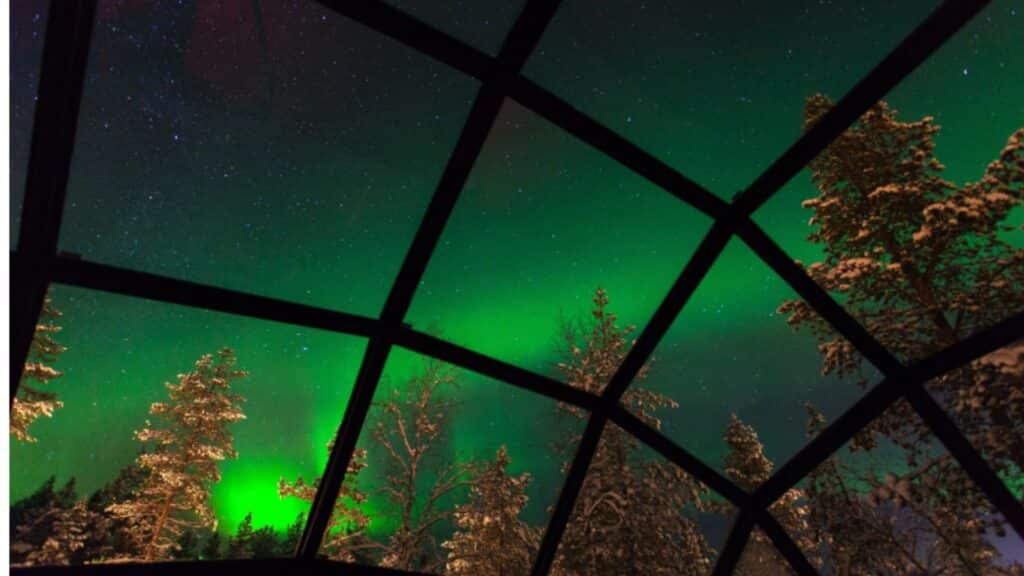 Glass igloo in Finland with Northern lights visible in the sky on a Collette tour