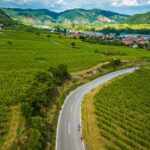 aerial view of vineyards and town with Backroads tour bicyclists on road