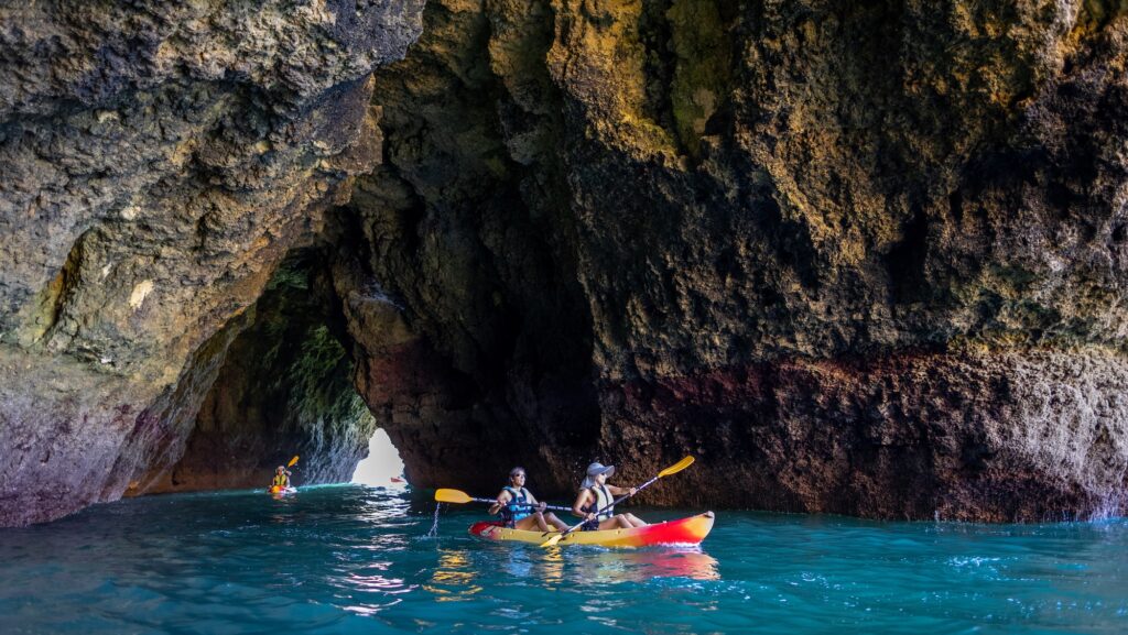 Kayakers on Backroads tour paddling through sea caves