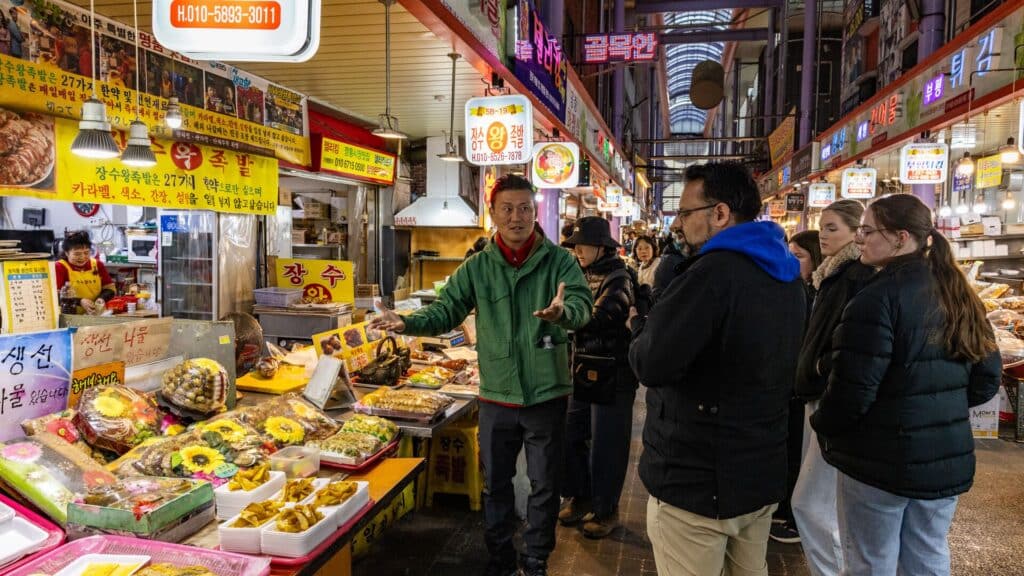 Intrepid tour of South Korea; guests and leader in a night market 