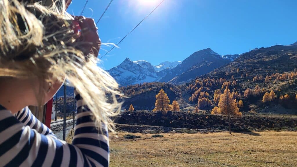 person taking photos out the window on the Bernina Express on a Byway low-impact tour in Europe