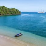 zodiac landing on quiet beach with azure water in Panama's Coiba National Park on a SeaCloud cruise