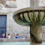 kids running behind fountain in the Barrio Gotico in Barcelona, Spain