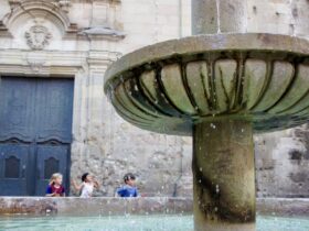 kids running behind fountain in the Barrio Gotico in Barcelona, Spain