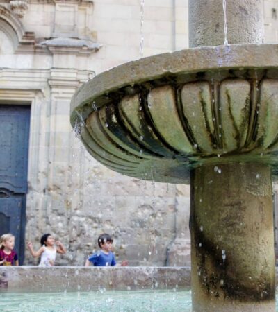 kids running behind fountain in the Barrio Gotico in Barcelona, Spain