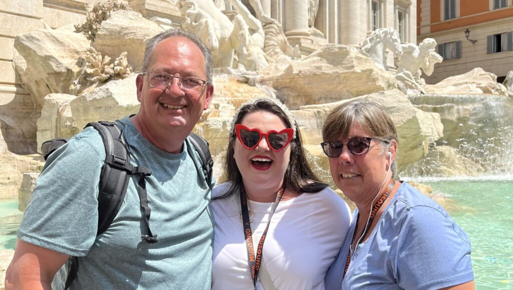 Megan and her parents in front of the Trevi Fountain in Rome.