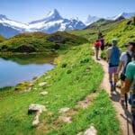 Family hiking on grassy area toward mountains