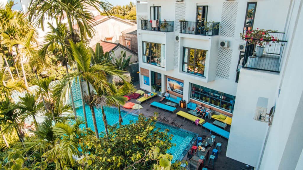 Multi-story apartment building with a pool in a tropical environment