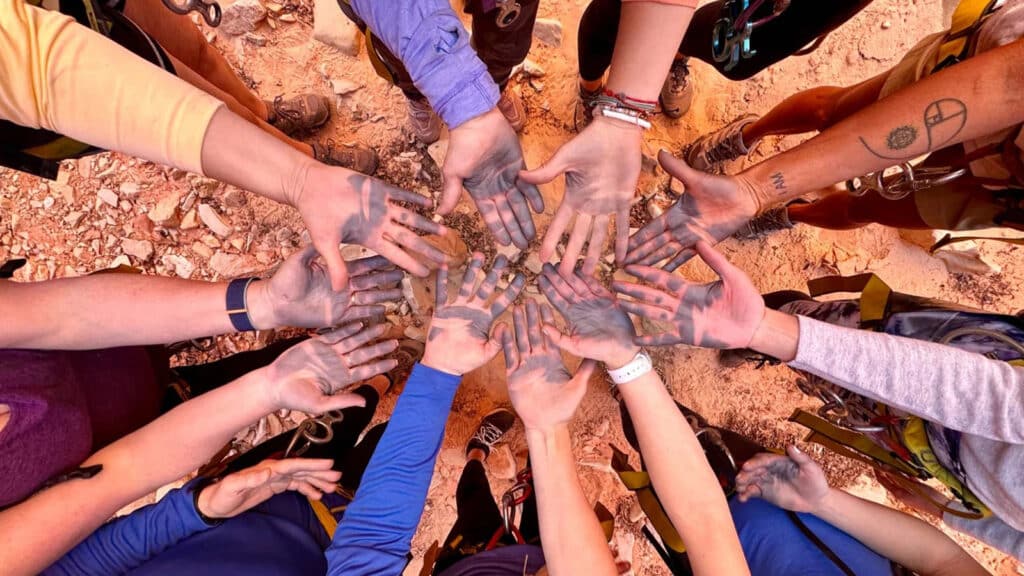 Women extending their arms into a center circle