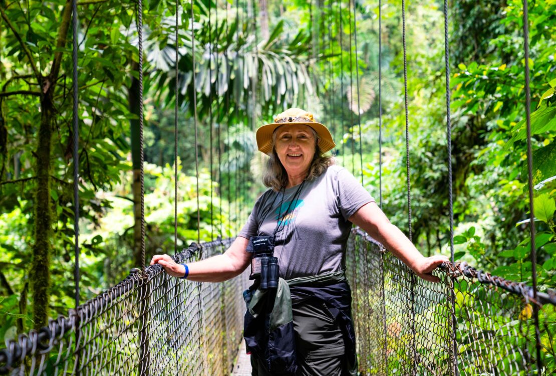 A woman standing on a rope bridge at the Arenal Volcano in Costa Rica on a Road Scholar tour