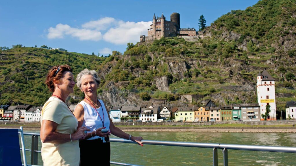 OAT tour participants on river ship looking out on Castle Katz