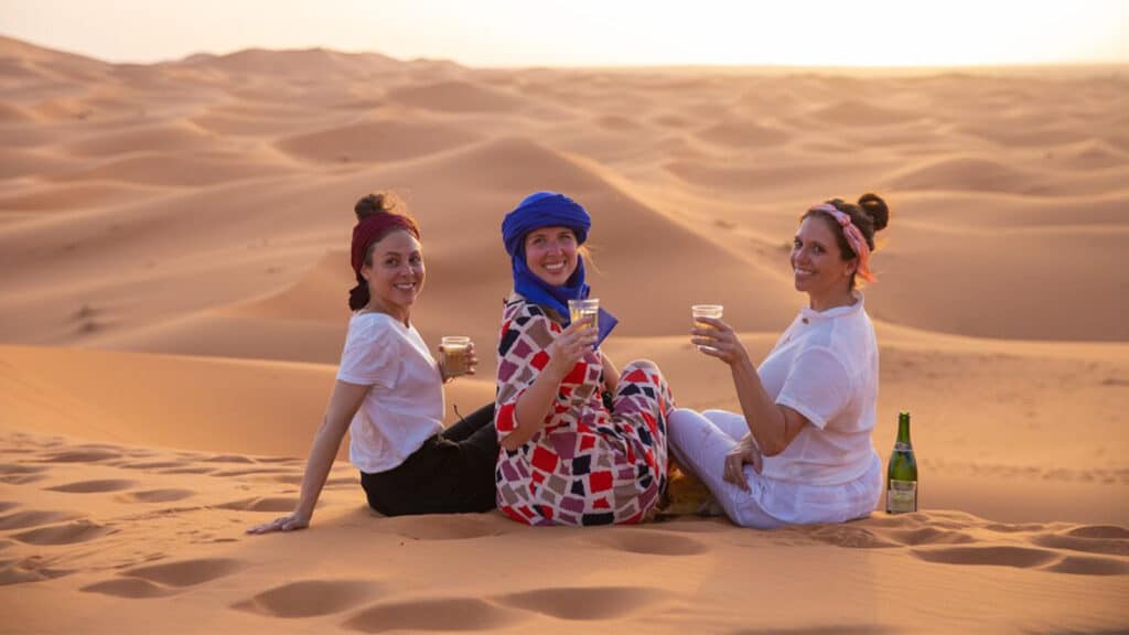 Three women having drinks in the desert