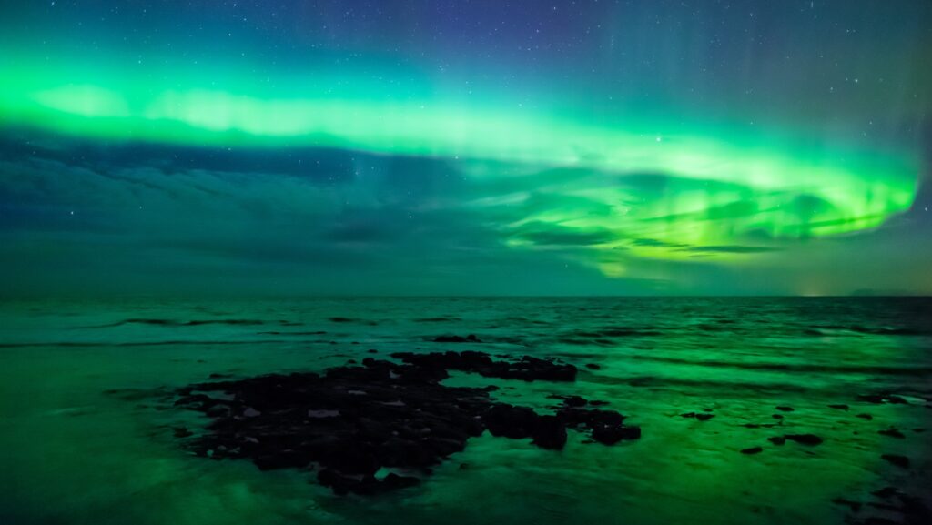 Aurora borealis display over the ocean in Iceland