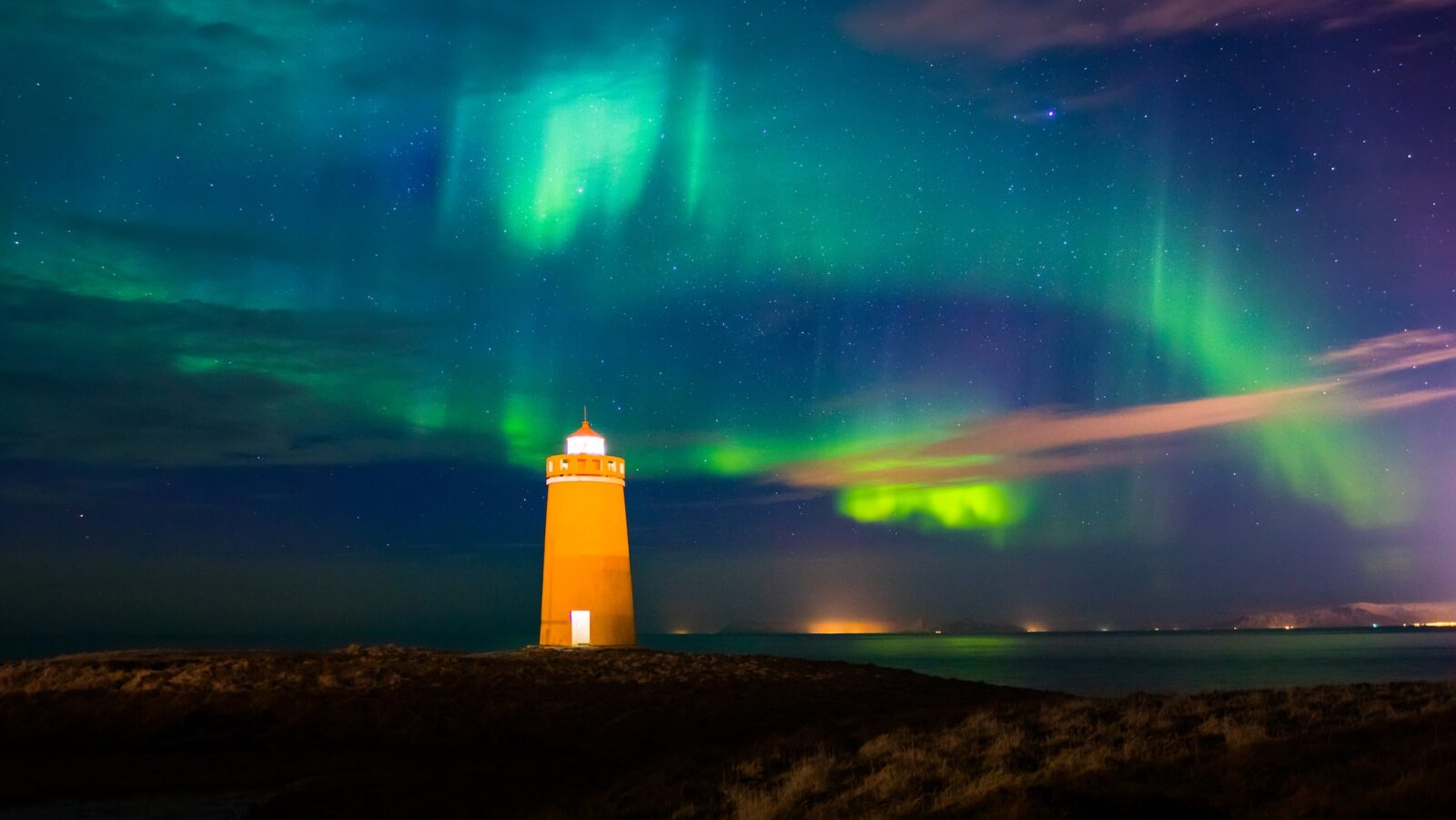 Lighthouse on Reykjanes peninsula under the aurora borealis in Iceland.