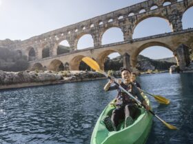 Two people kayaking under an arched bridge