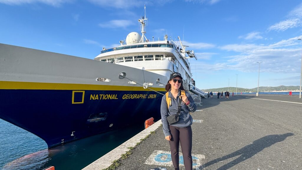 Travel journalist Carly Neil in front of the National Geographic - Lindblad Expeditions ship The Orion on a Dalmation Coast expedition cruise