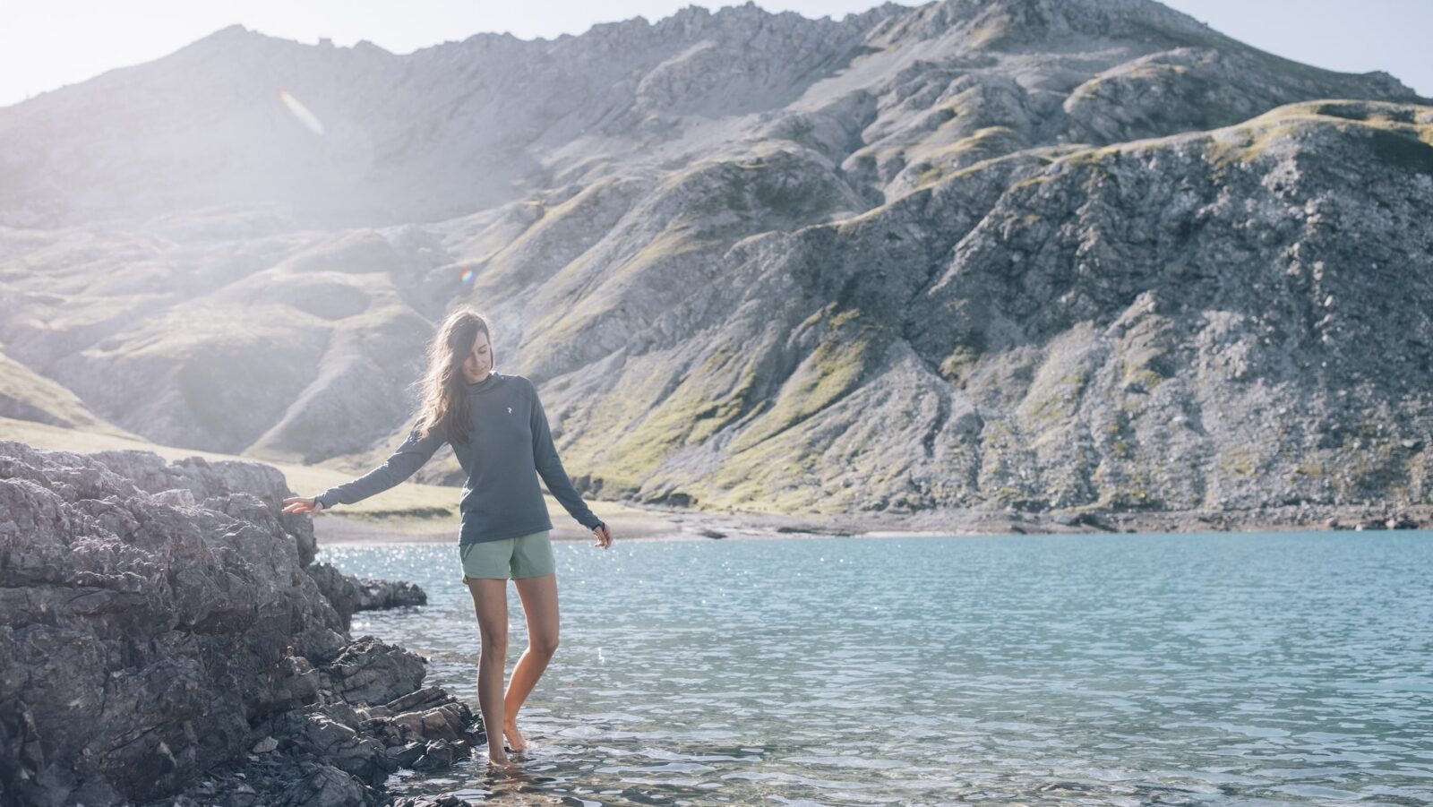 A woman walking barefoot in a mountain lake in Austria