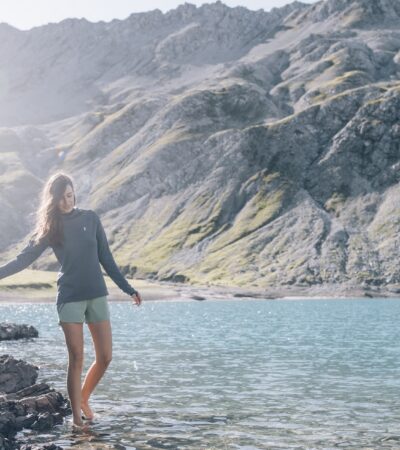 A woman walking barefoot in a mountain lake in Austria