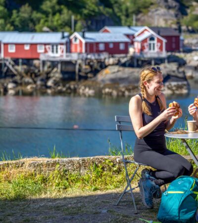 Two women eating in front of the water with red buildings behind them on a Backroads tour in Norway