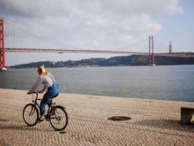A woman riding a bike on a stone pathway near the Golden Gate Bridge