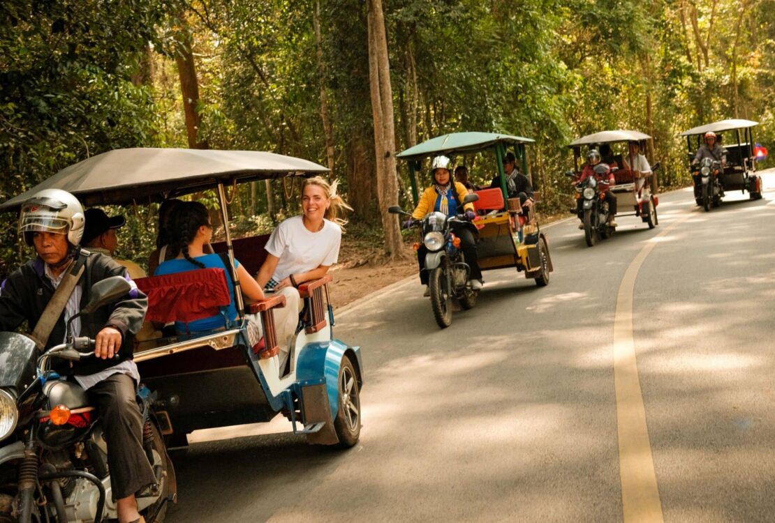 Four tuk tuks transporting travelers on Contiki's new Ride Cambodia tour