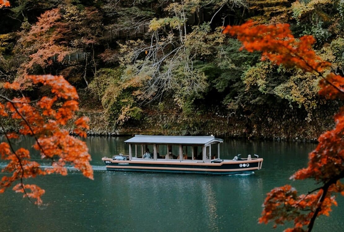 A boat in the water framed by blooming trees in Japan